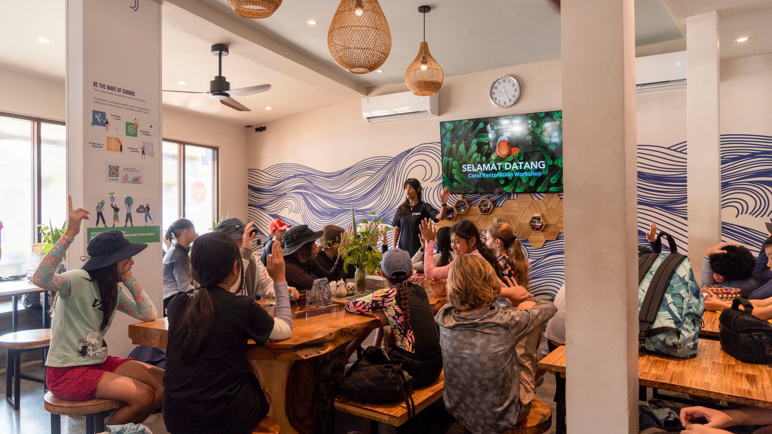Guests listening to a briefing in our dive centre, with a welcome slide on the screen